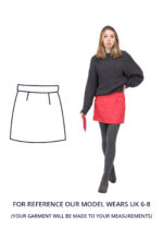 Charlotte is wearing a hot pink mini skirt with a grey jumper and tights. Charlotte is stood facing the camera with one hand on their hip and one down holding an Emperor's tablet case.