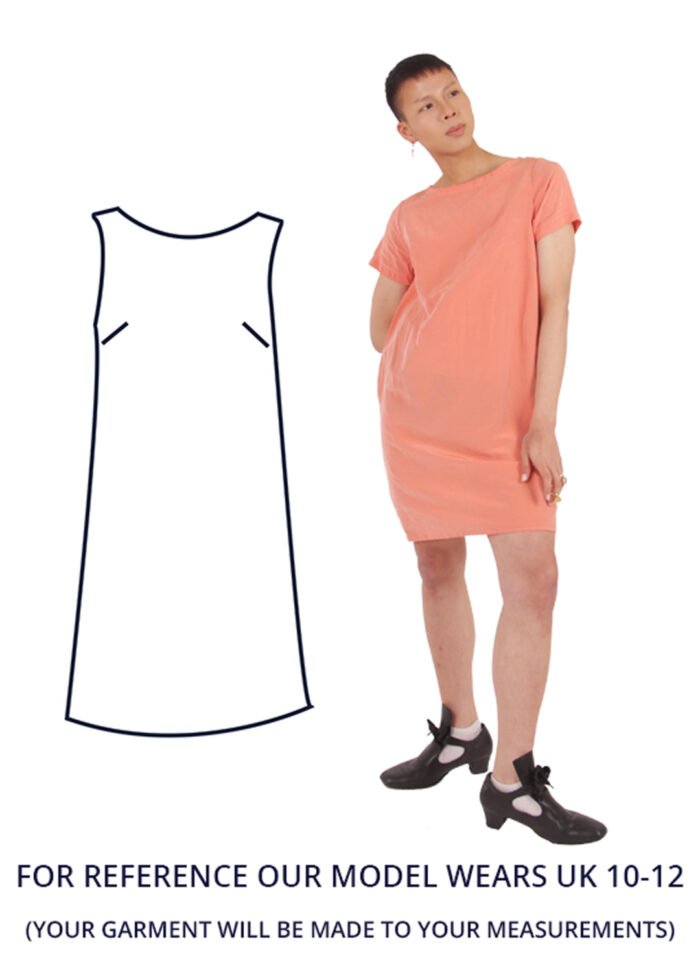 An is wearing a salmon pink shift dress with short sleeves.