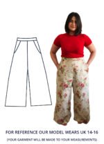 Our model Fenia is stood with their hands in their pockets of their floral wide leg trousers. Fenia is wearing a bright red t-shirt and is barefoot.